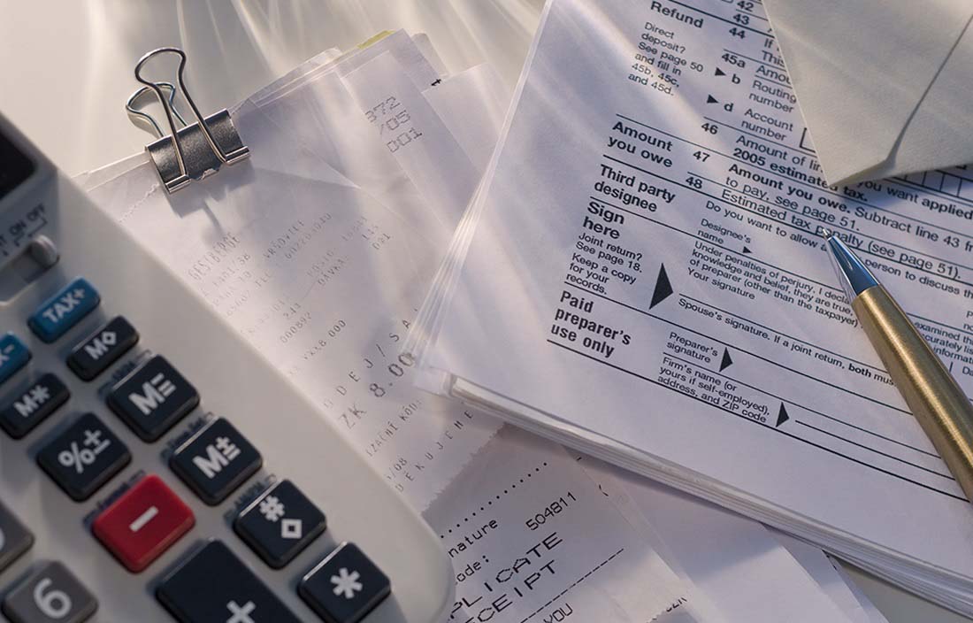 Close up image of calculator and tax paperwork on a desk.