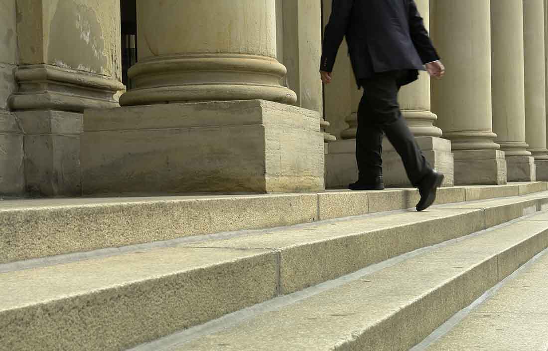 Close-up view of a business professional walking up concrete steps.