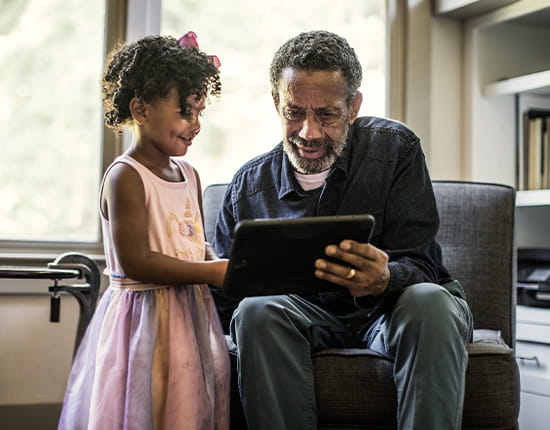 Elderly man and daughter using a tablet. 