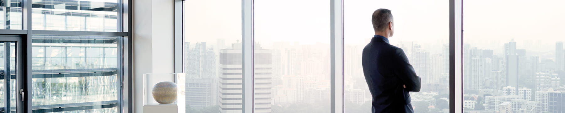 Man looking out window as sun rises