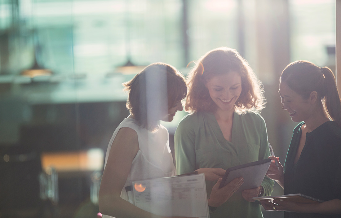 Image of three women looking at a document