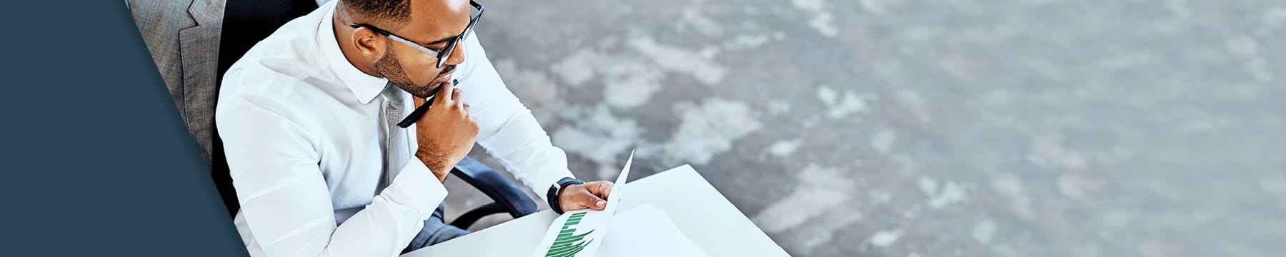 Businessman looking at data and charts on a piece of paper.