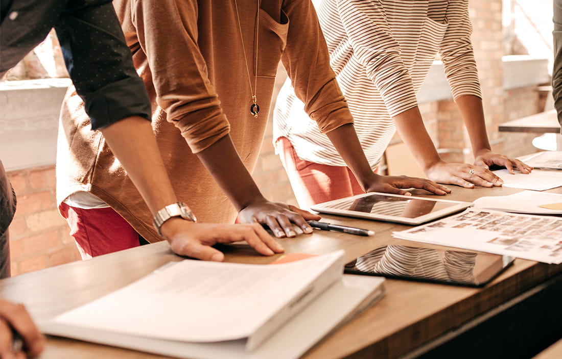 Image of people leaning on a desk with their hands