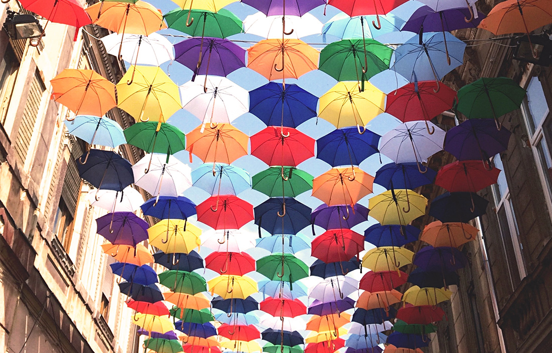 Image of umbrellas floating in air between two buildings