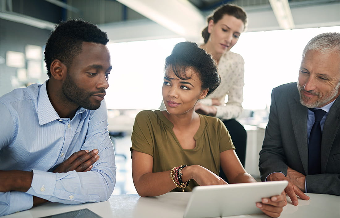 image of four people looking at a tablet