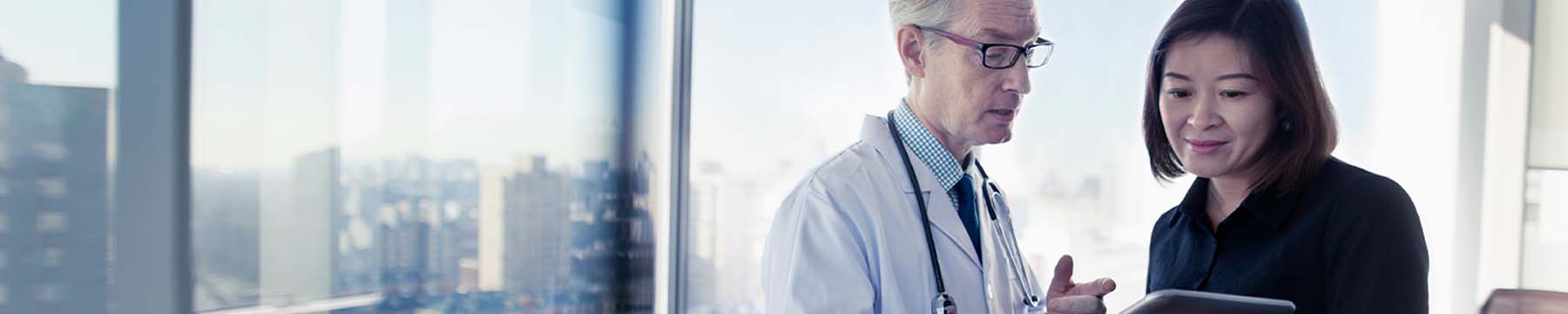 Doctor holding a tablet discussing results with a colleague.
