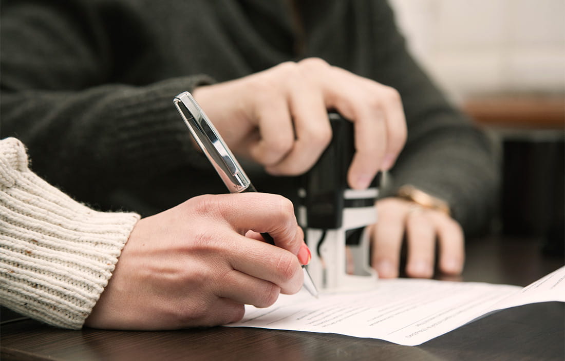 Image of a person signing a document