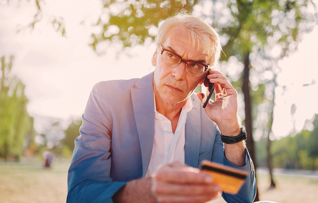 Image of man on on phone with his credit card