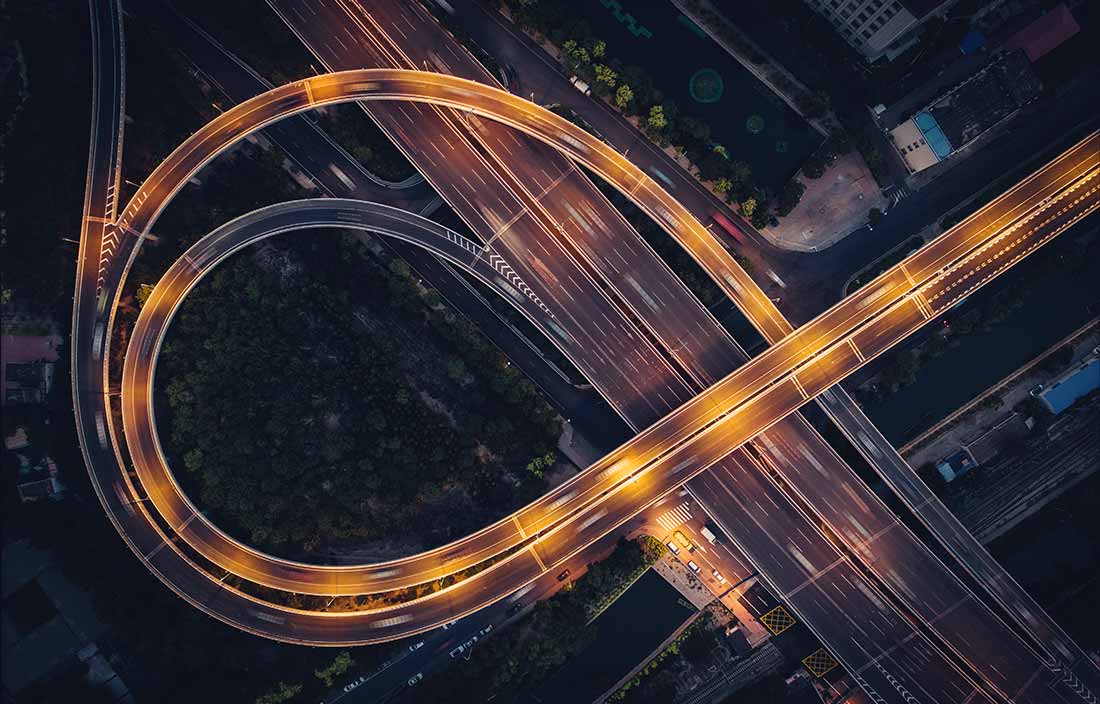 Top down view of a highway and roads at dusk.