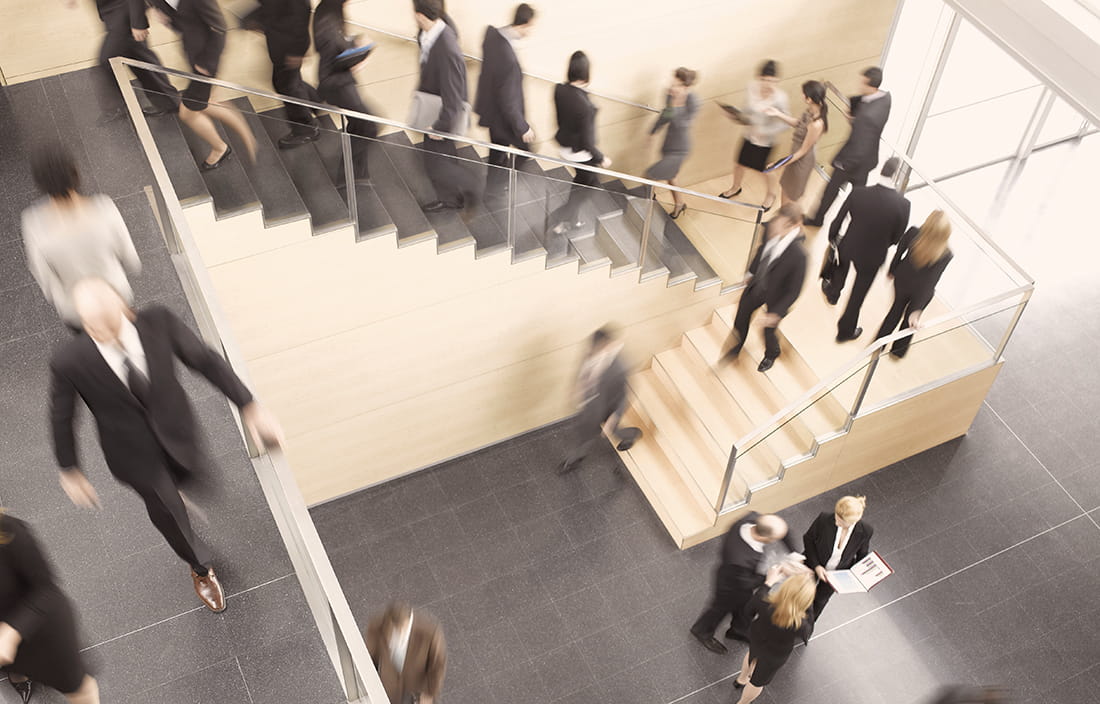 A crowd of people walking up and down stairs. 