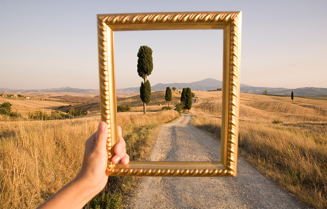 Holding up a picture frame to landscape