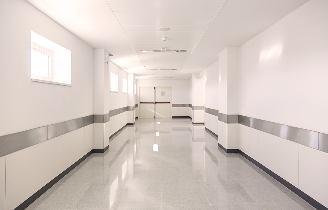 View down white hospital hallway.