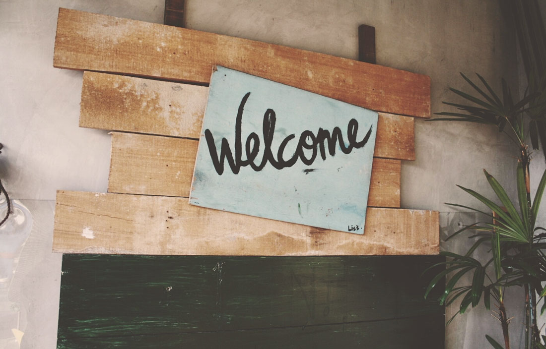 Image of handwritten "Welcome" on natural wood boards