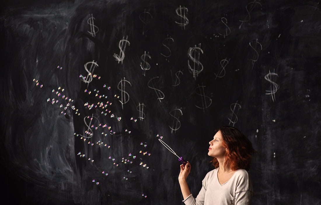 Image of woman blowing bubbles in front of chalk board with dollar signs
