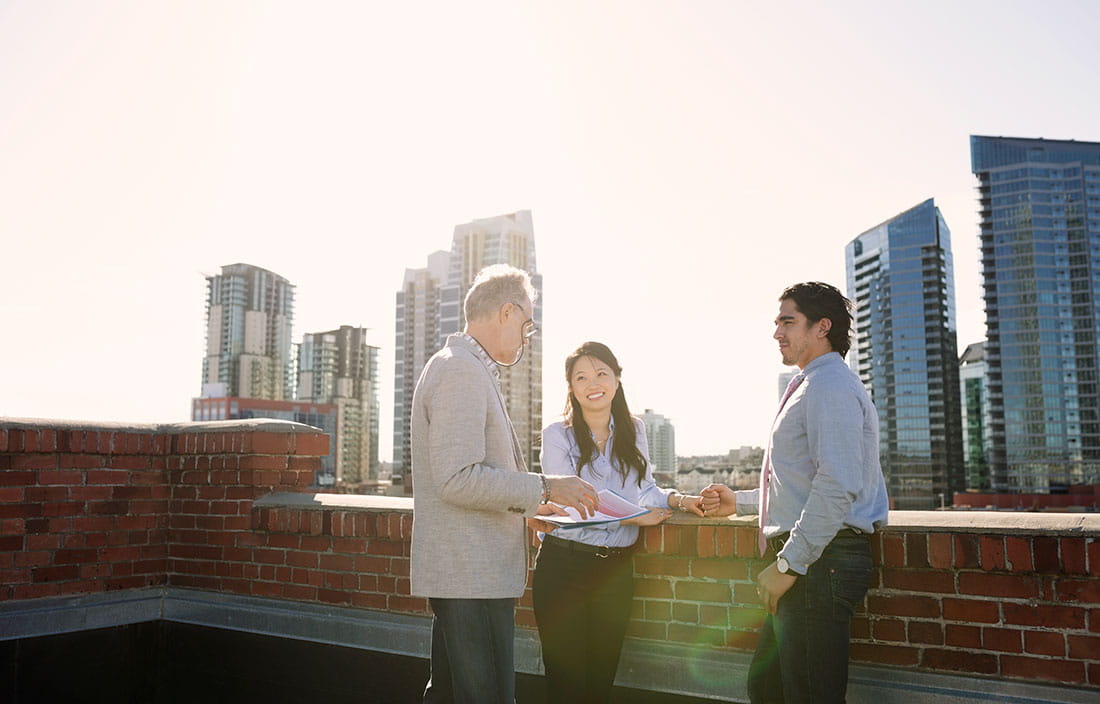 Image of diverse group holding meeting on rooftop