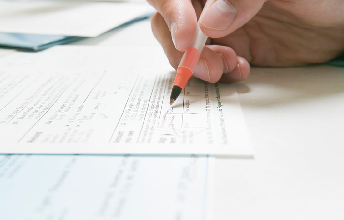 Image of hand holding pen and writing