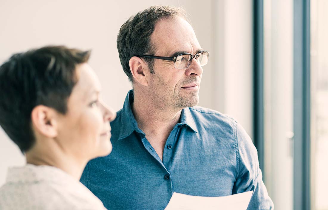 Image of man and woman staring out of window. 