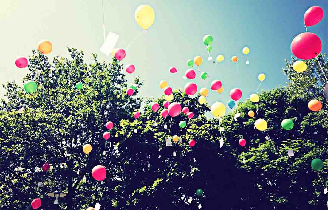 Image of balloons floating out of trees