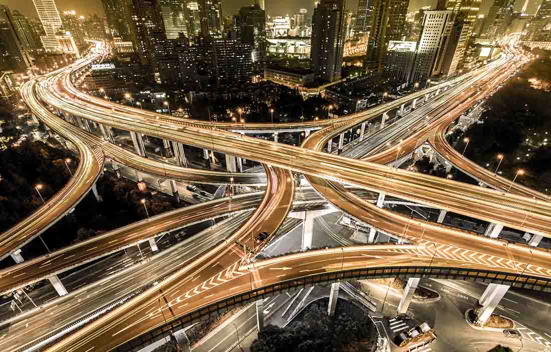 Birds-eye view of a busy highway section at night. 