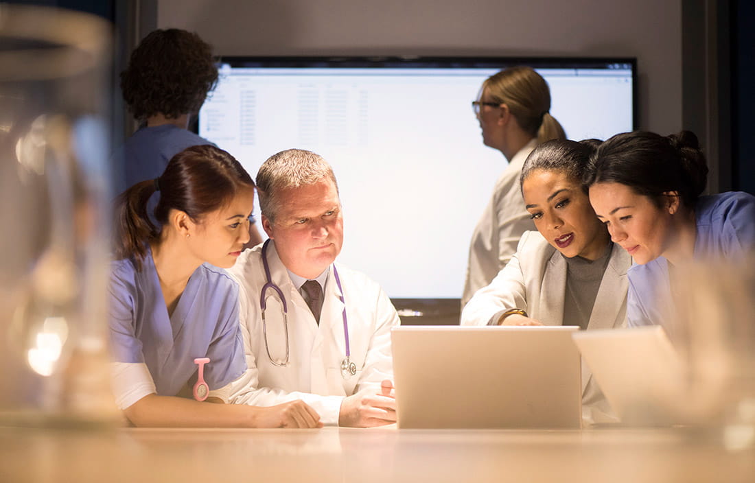 Healthcare providers review data on a laptop