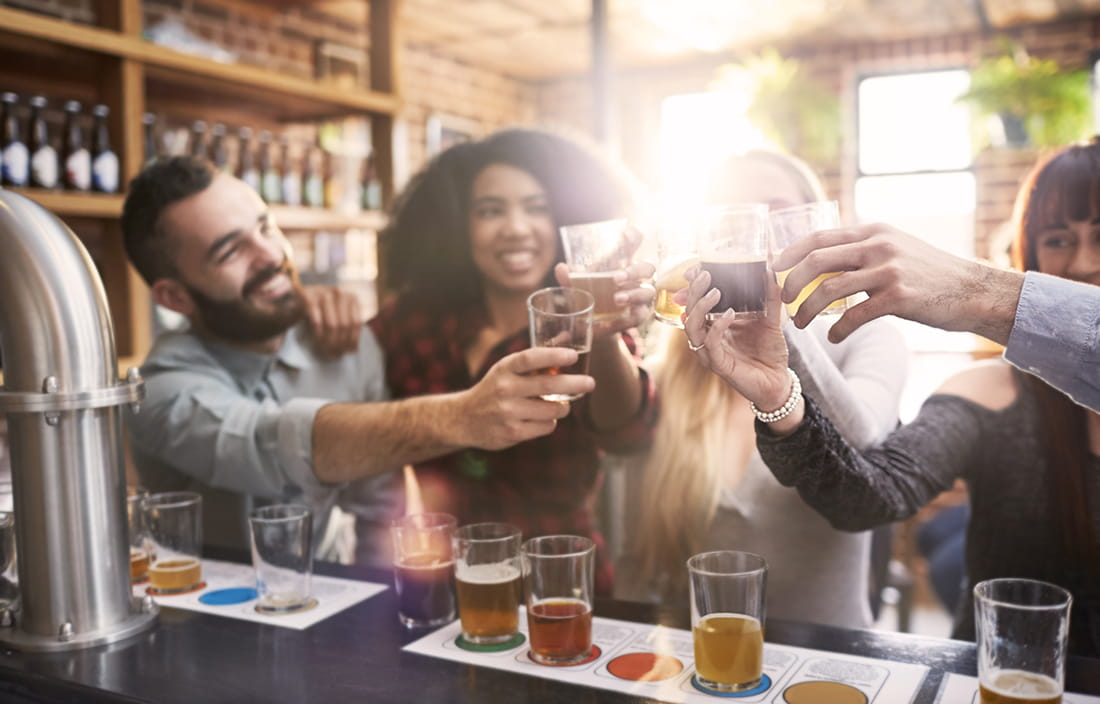 Group of friends sharing a flight of beer.