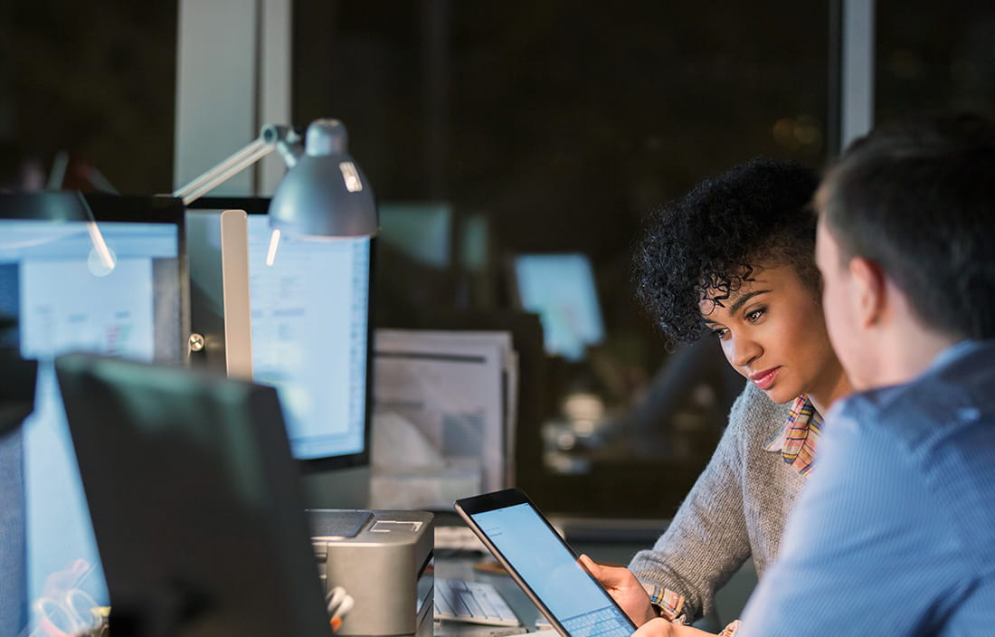 Image of two people looking at laptop