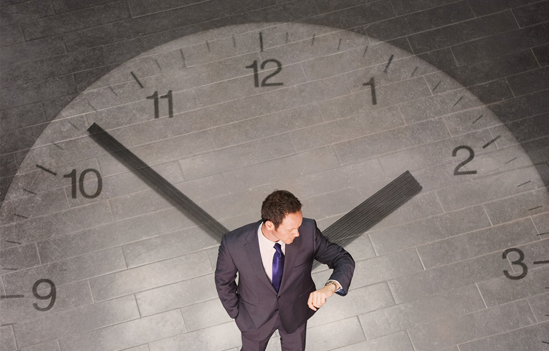 Image of man standing with clock projected behind him