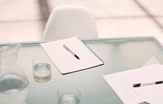 Image of a desk with paper and pen