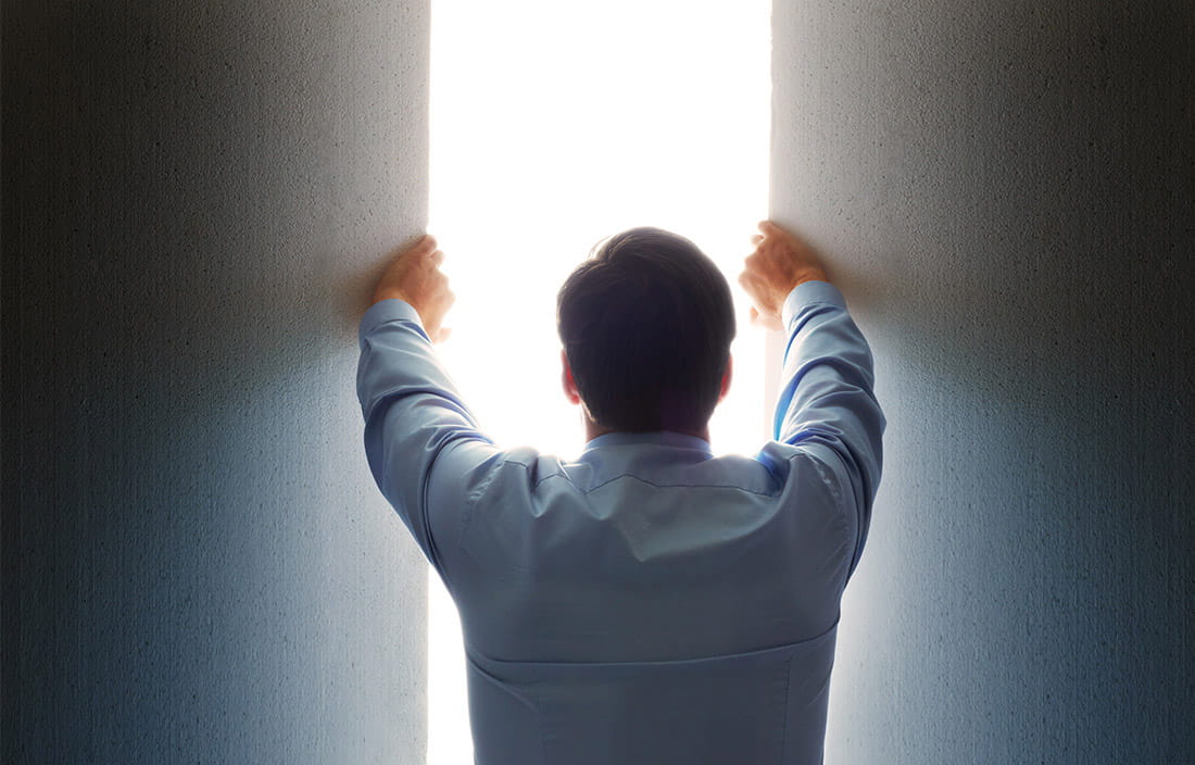 business man opening opening nondescript panels to let in bright light
