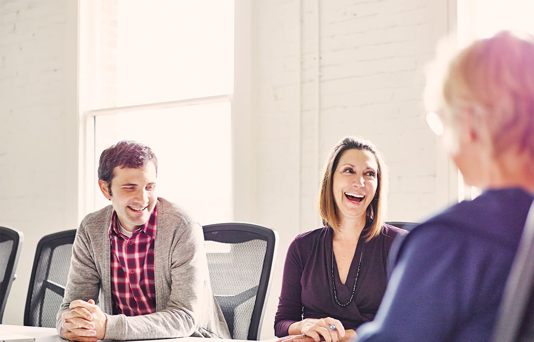Image of people laughing during a meeting