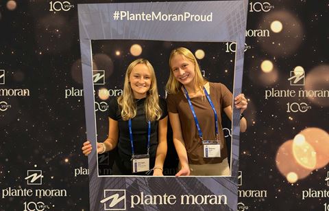 Plante Moran interns posing with proud portrait at event