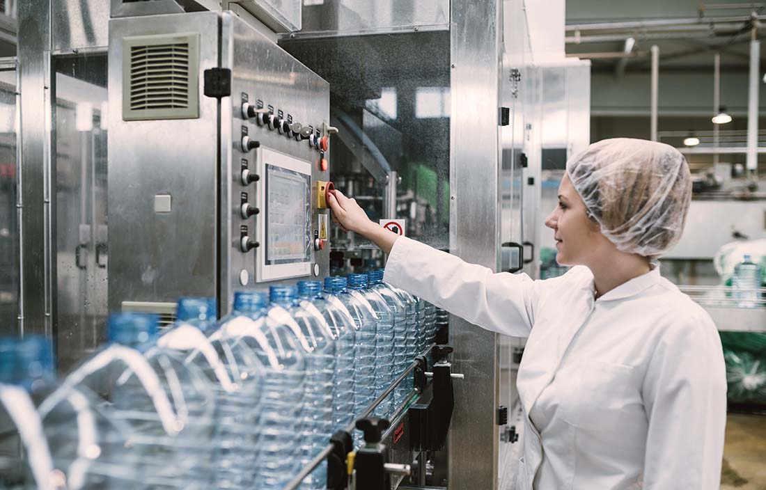 Lady working in a factory using an industrial machine. 