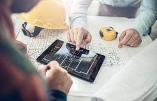 Construction professional reviewing blueprints.