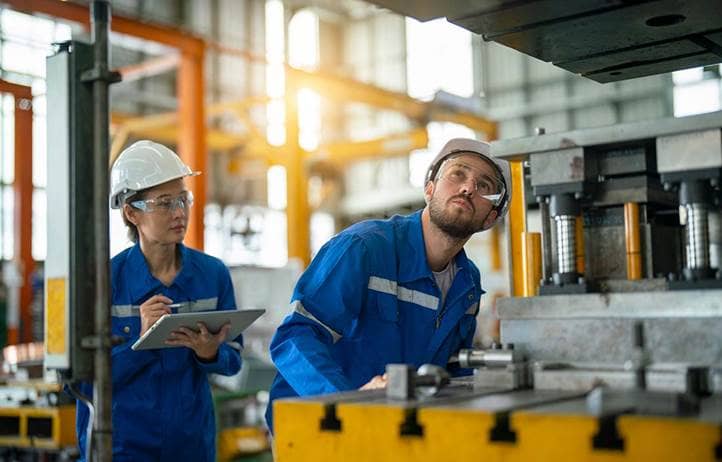 Manufacturers inspecting factory machines.