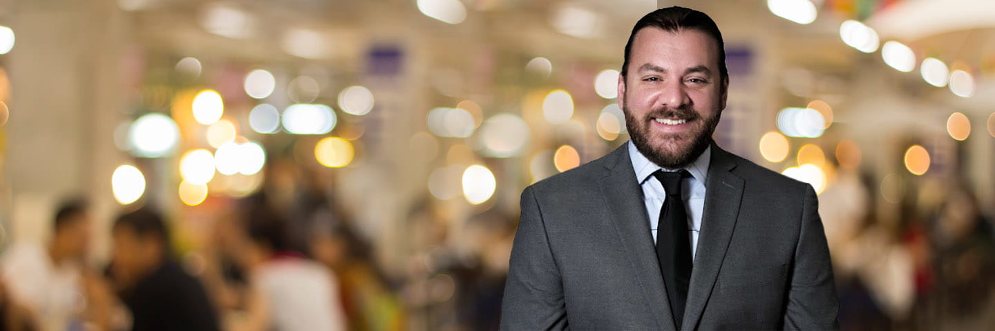 Professional photo of Cole Weinman in front of brightly colored, blurred background.