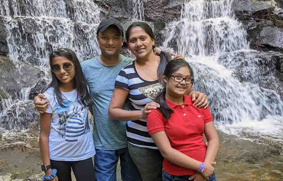 Picture of a family standing nearby a waterfall.