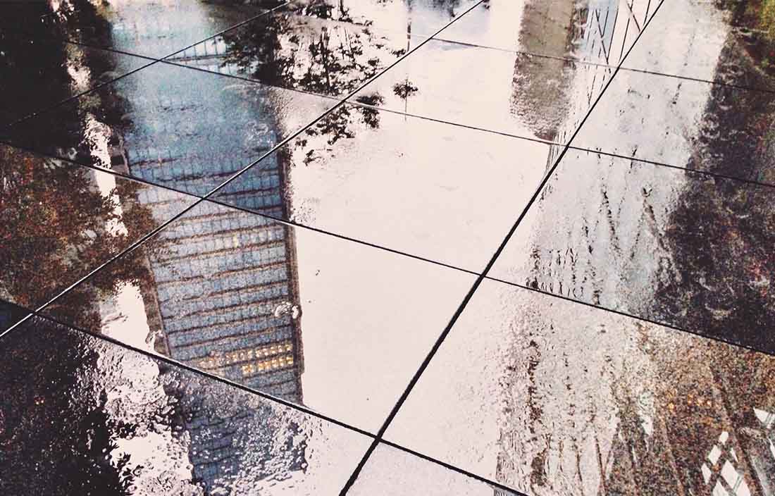 Reflection of skyscraper on wet pavers
