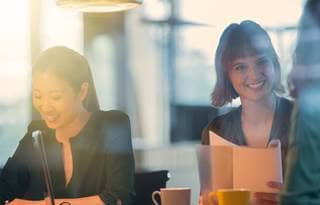 Two business women smiling at work