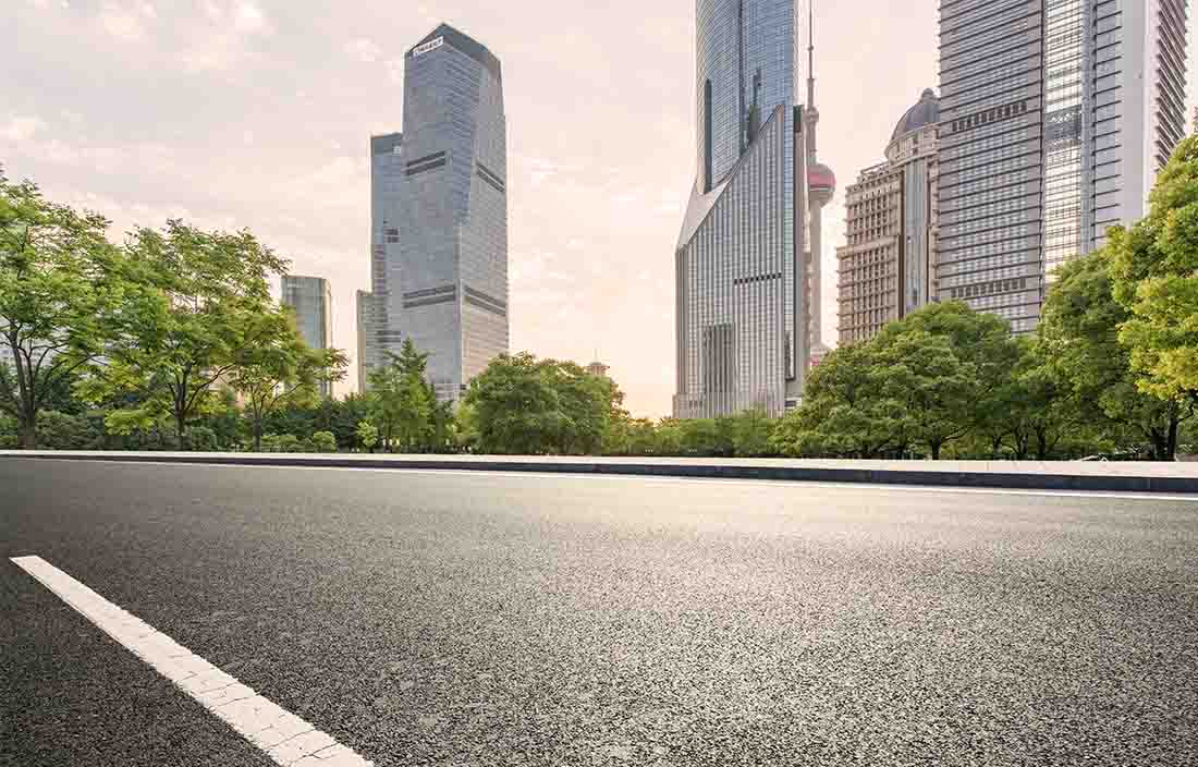 closeup of city road with modern skyscrapers in the background