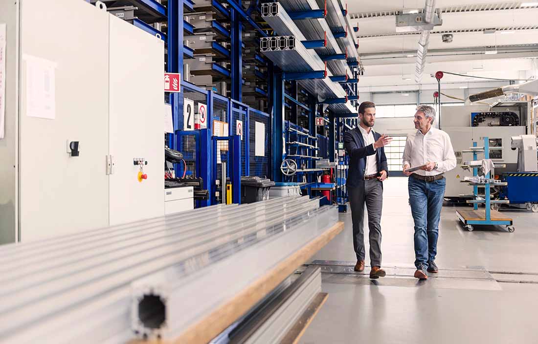 Two professionals walking on a manufacturing plant floor