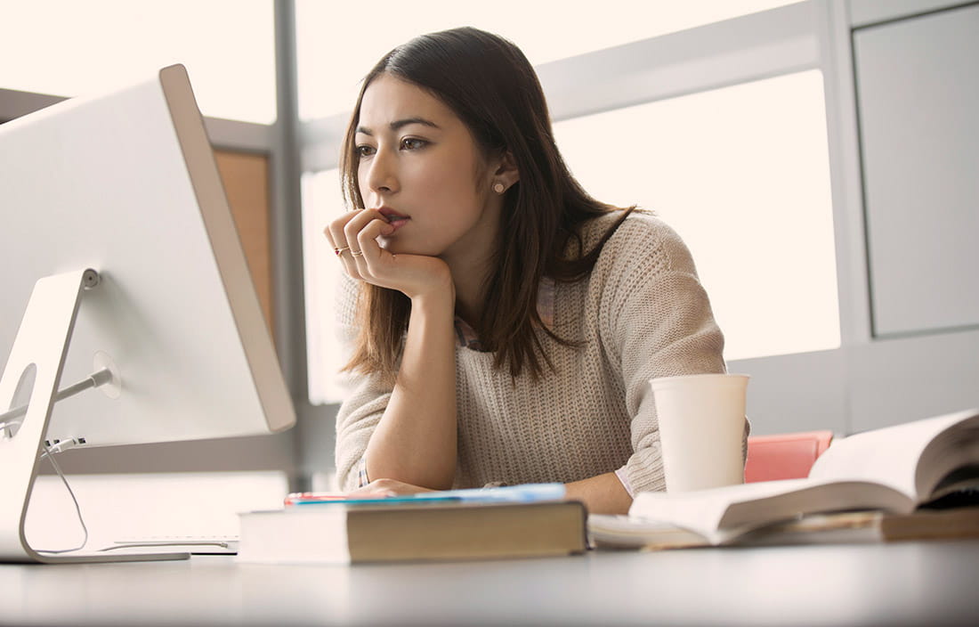 Woman sitting at desk looking at her computer