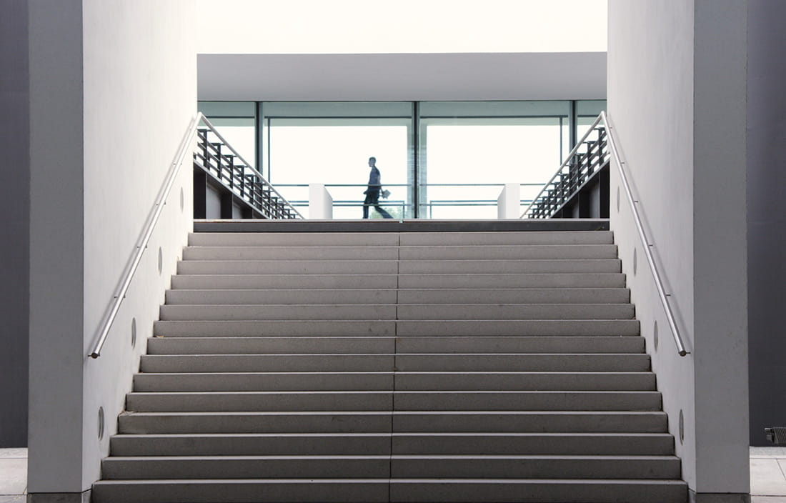 One person walking by a large staircase