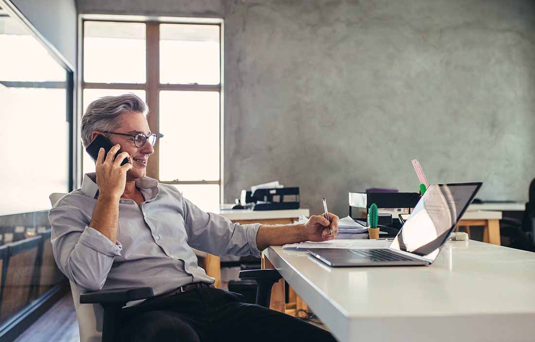 Man sitting at a desk talking on his phone