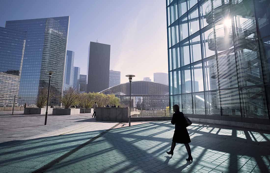 Woman walking through a downtown courtyard area.