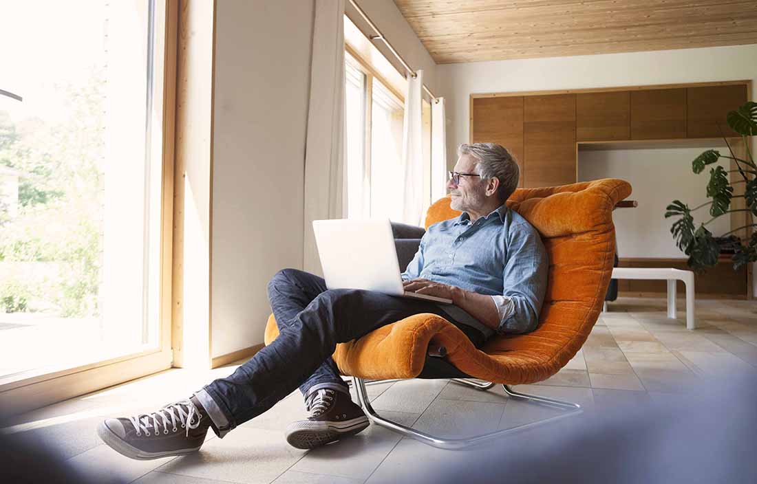 Man sitting in a lounge chair on his laptop