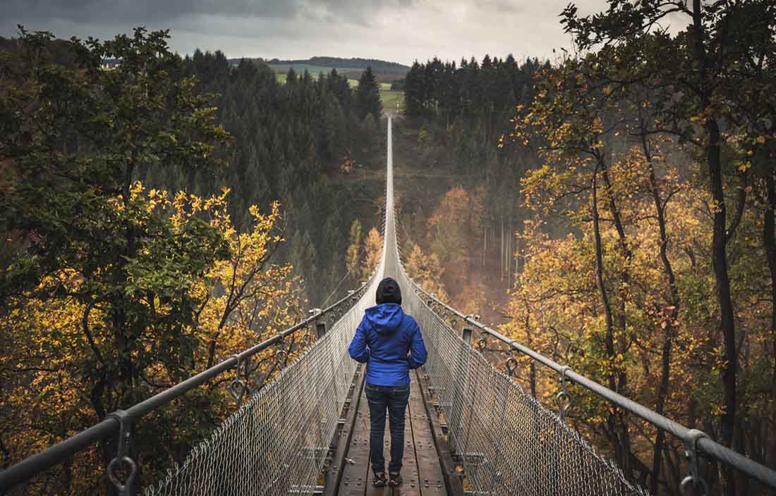 Person walking across a suspension bridge