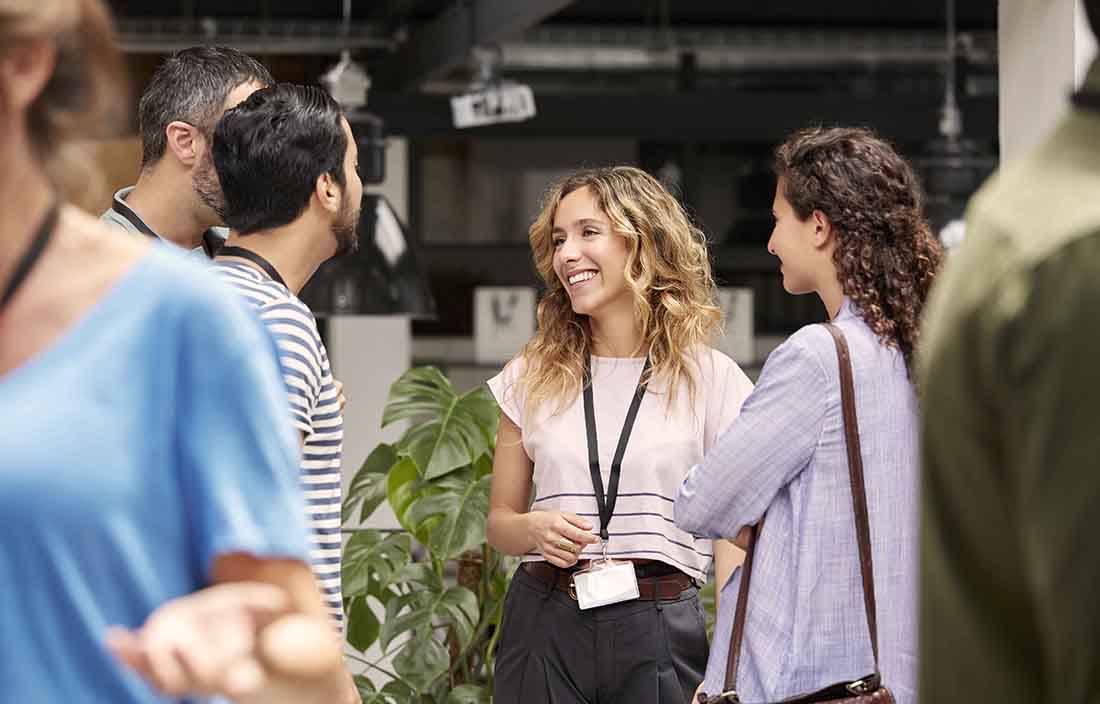 Business professionals standing talking while at a conference.