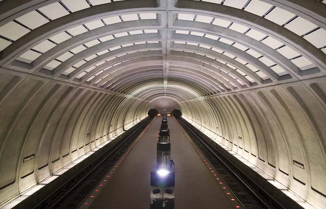 View of a tunnel with cars driving on a road.