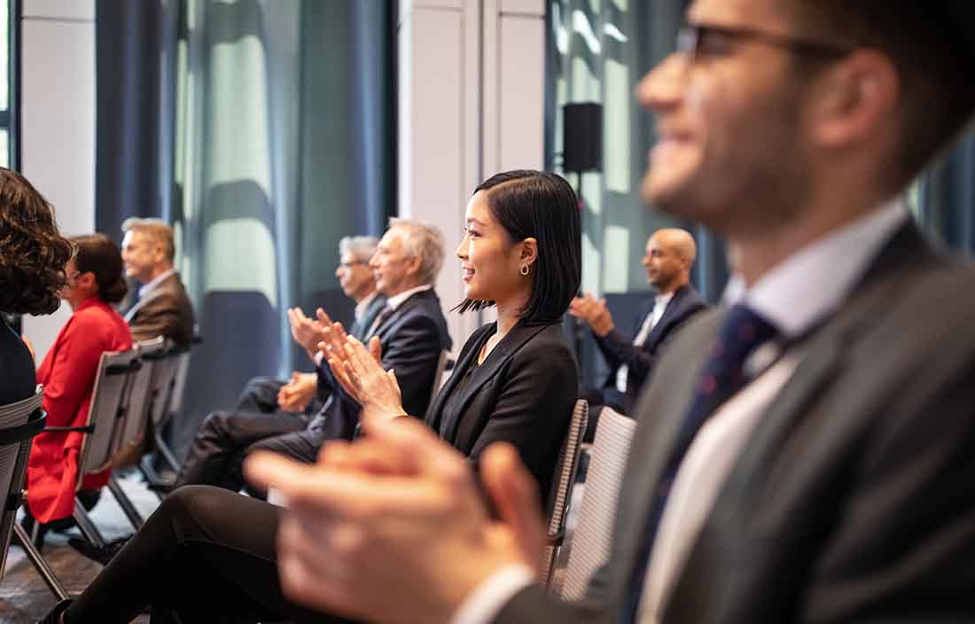 Conference attendees clapping at a conference.