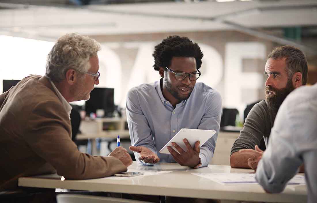 Business professionals having a meeting around a table in casual business attire.